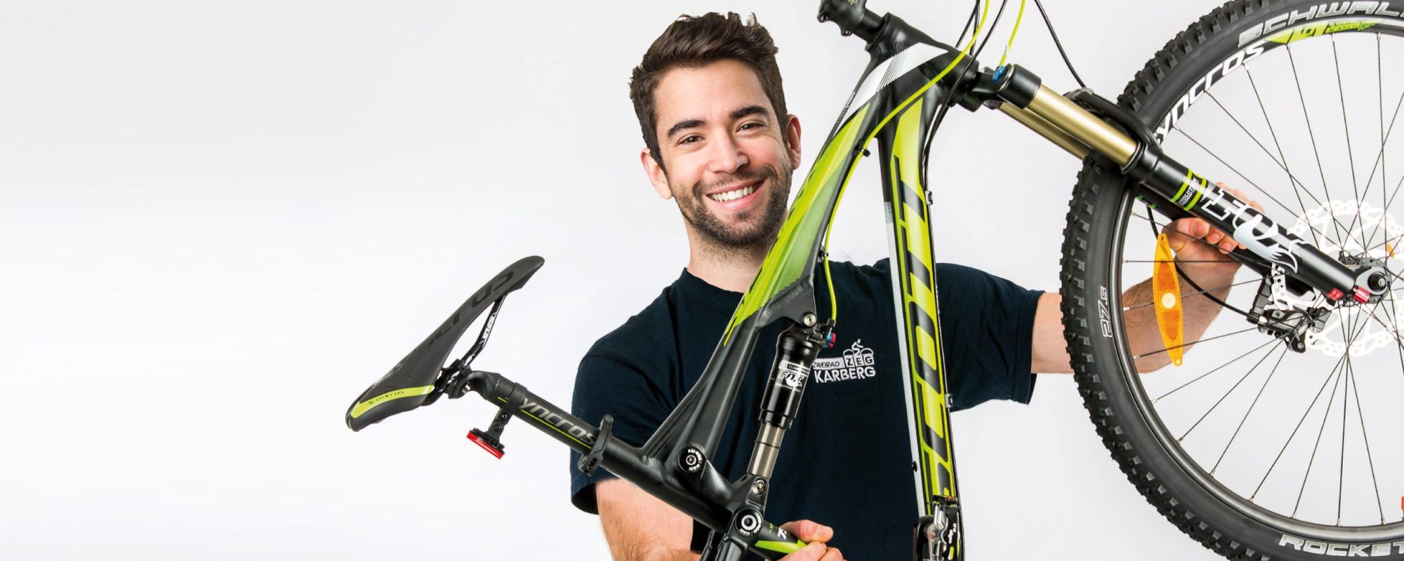 Zweirad Karberg-Mitarbeiter hält ein Fahrrad Mountainbike hoch